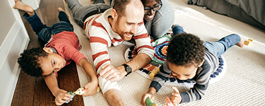 Jeune famille qui joue dans le salon