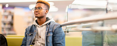 Photo d’un homme assis dans une bibliothèque