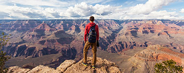 Homme se tiens devant paysage canyonique 