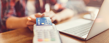 Woman holding her card up to a payment terminal