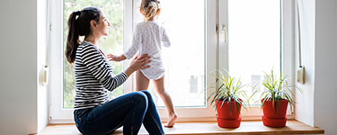 Femme aide sa fille qui apprend à marcher