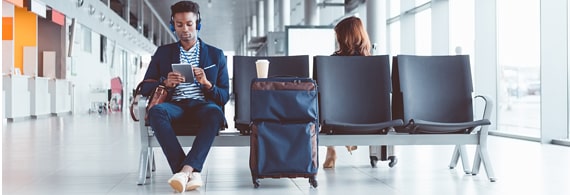 Homme assis à l'aéroport avec ses bagages