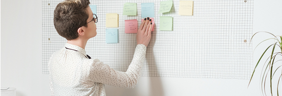 Femme professionnelle colle des notes sur un tableau