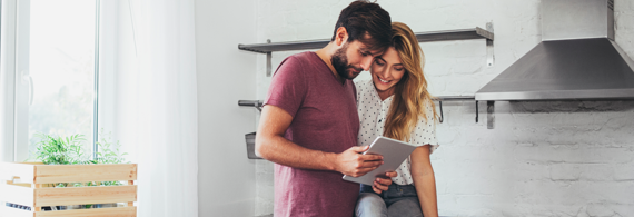 Couple planifie son voyage en regardant une tablette