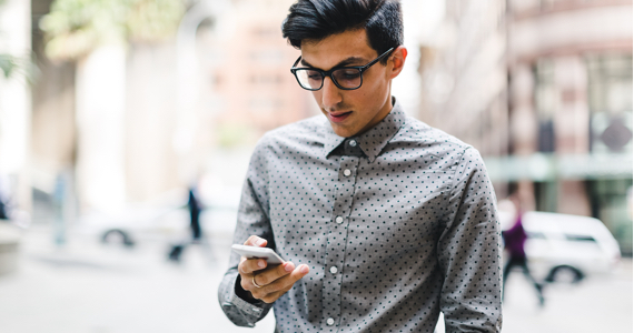 Homme dans la rue regarde son téléphone