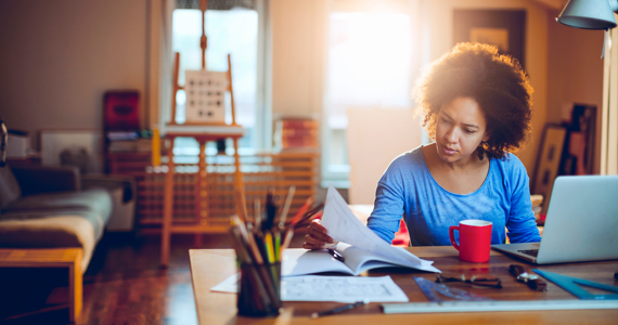 Étudiante assise à son bureau lit un document