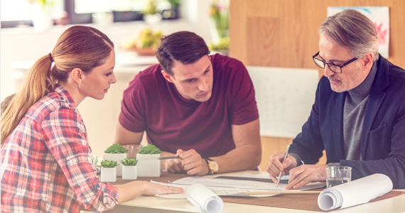 Jeune homme et jeune femme discutent avec un architecte