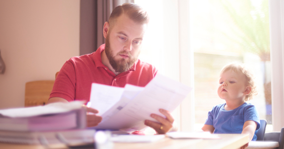 Jeune enfant regarde un homme qui classe ses papiers