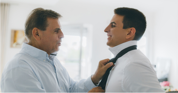 Homme noue la cravate d’un homme plus jeune