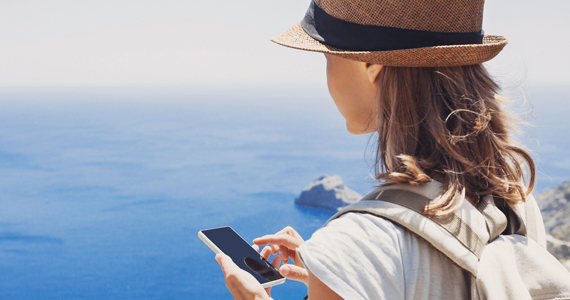 Femme en voyage à la mer utilise son téléphone