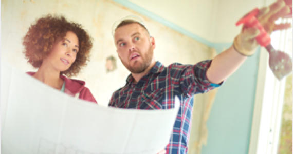 Jeune femme qui tient un plan de maison discute avec un jeune homme