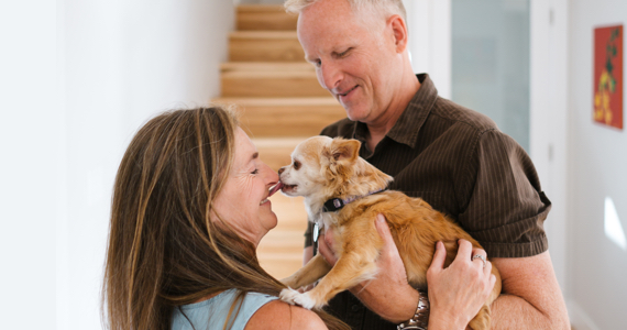 Couple de retraités tiennent un petit chien dans leurs bras