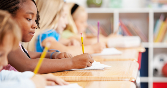 Enfants dans une salle de classe écrivent dans un cahier