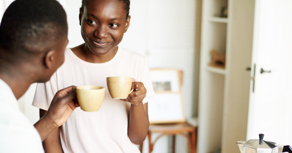 Homme et femme se regardent en tenant une tasse de café