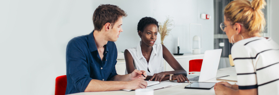 Couple assis à une table avec conseillère bancaire