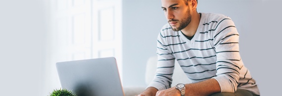 Jeune homme travaille à son ordinateur