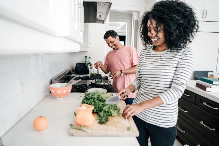 Femme qui coupe des légumes sur une planche à découper