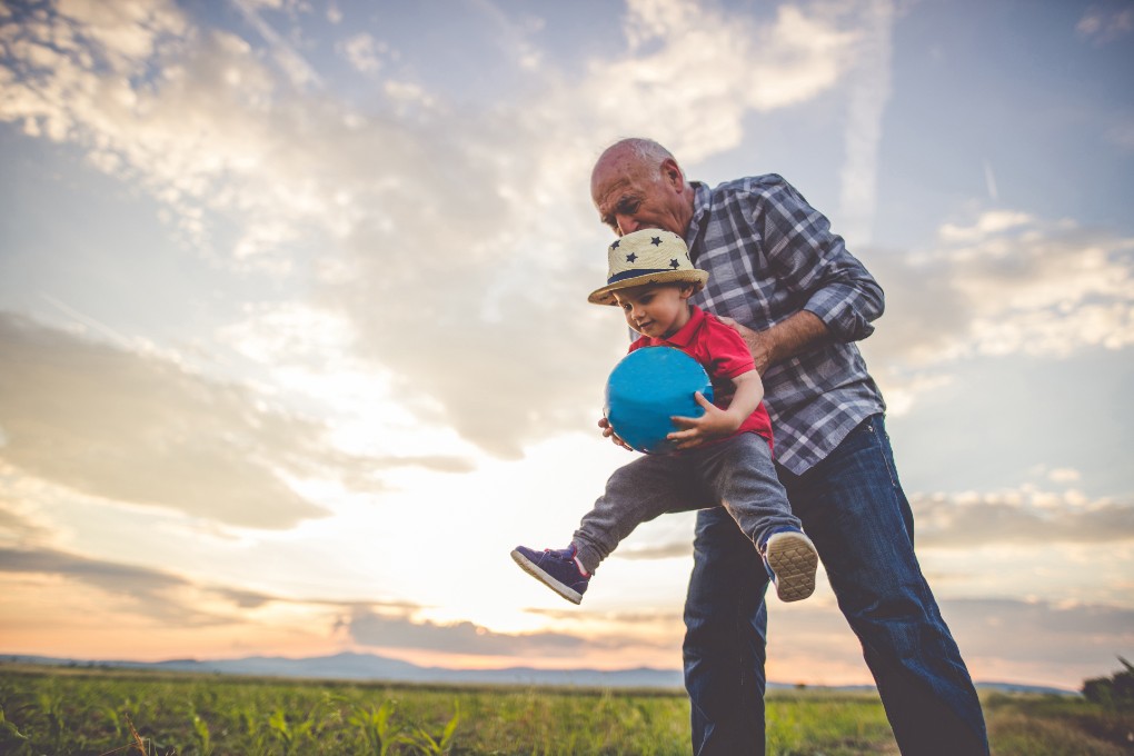 Photo d’un grand-papa qui soulève son petit-fils 