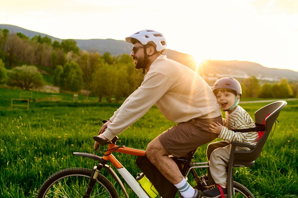 Père avec son fils sur un vélo profitant de son épargne