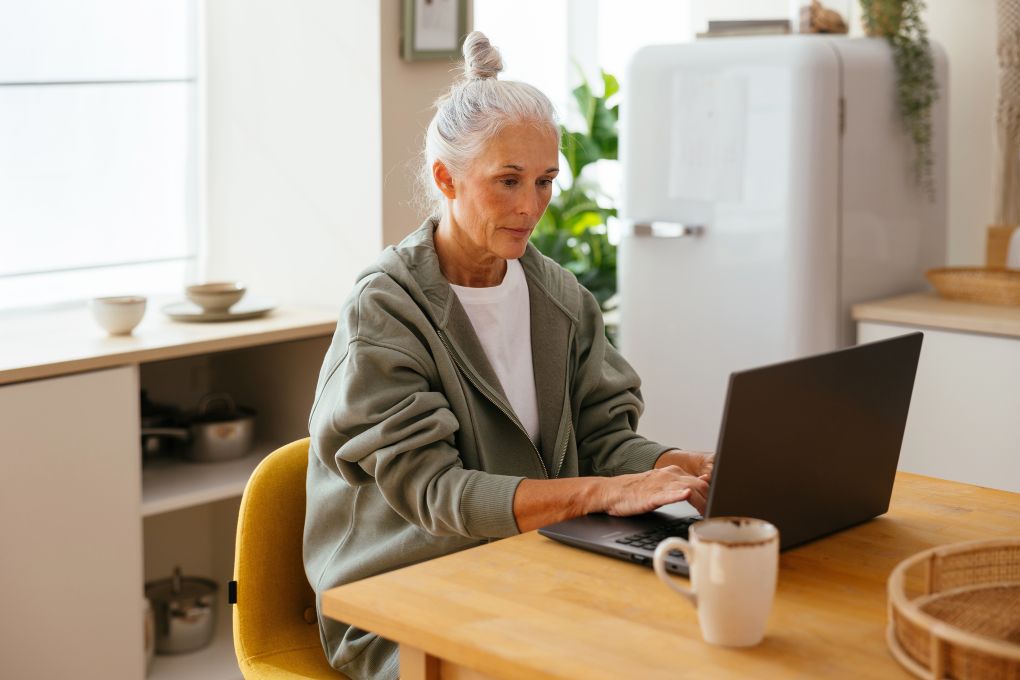 Femme retraitée s’informant sur les marchés sur un ordinateur