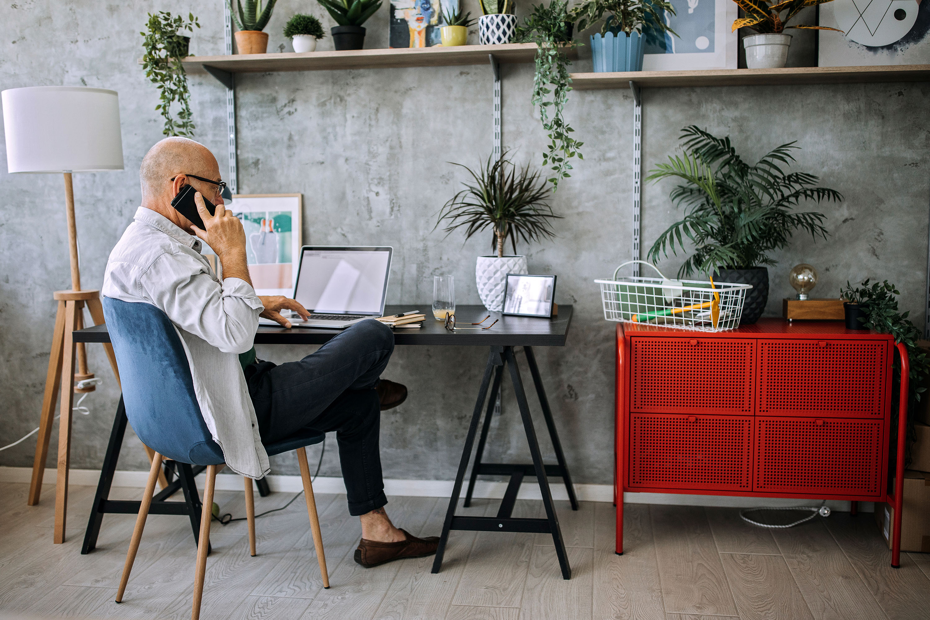 Entrepreneur assis à son bureau qui parle de décaissement de ses actifs pour la retraite au téléphone