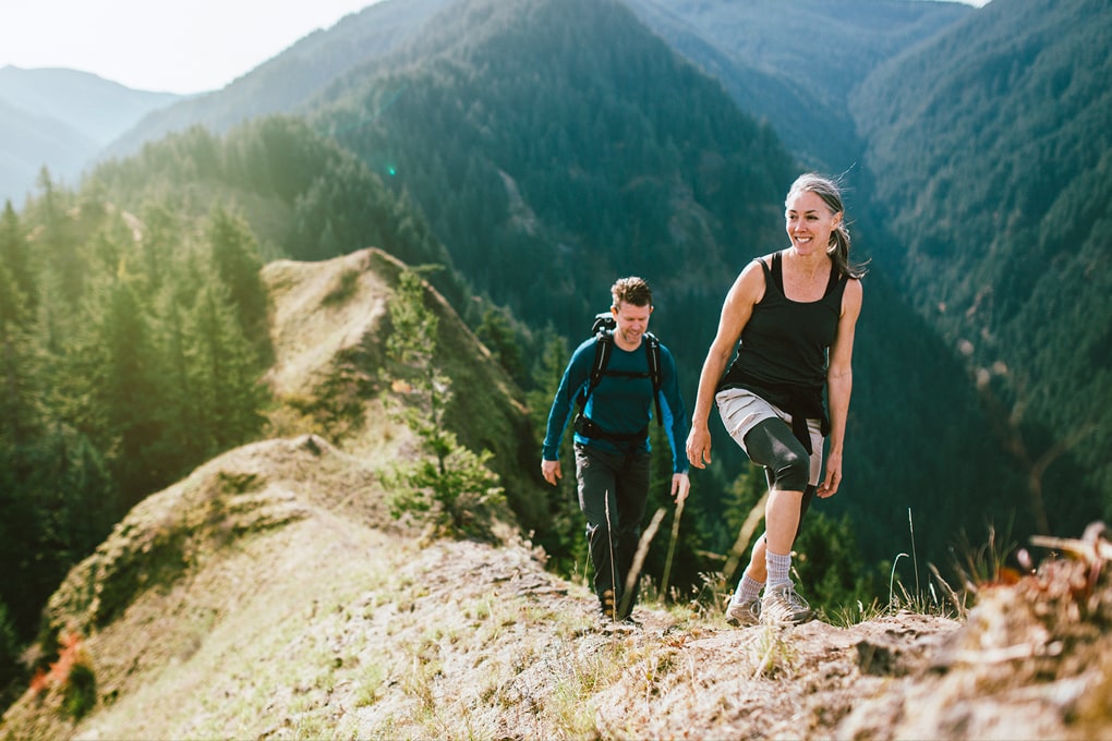 Photo d’une femme et d’un homme en randonnée au sommet d’une montagne 