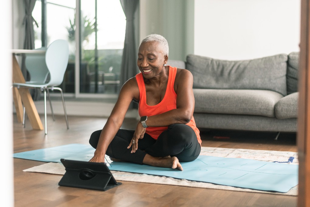 femme-yoga-tablette-retraite Femme retraitée qui s’apprête à faire du yoga avec sa tablette.