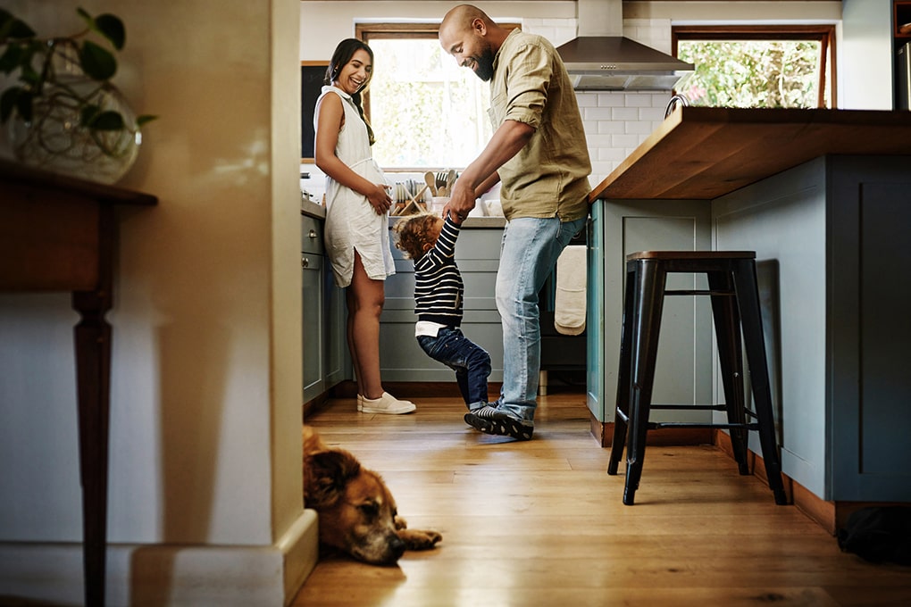 Couple et un enfant qui sont debout dans leur cuisine 