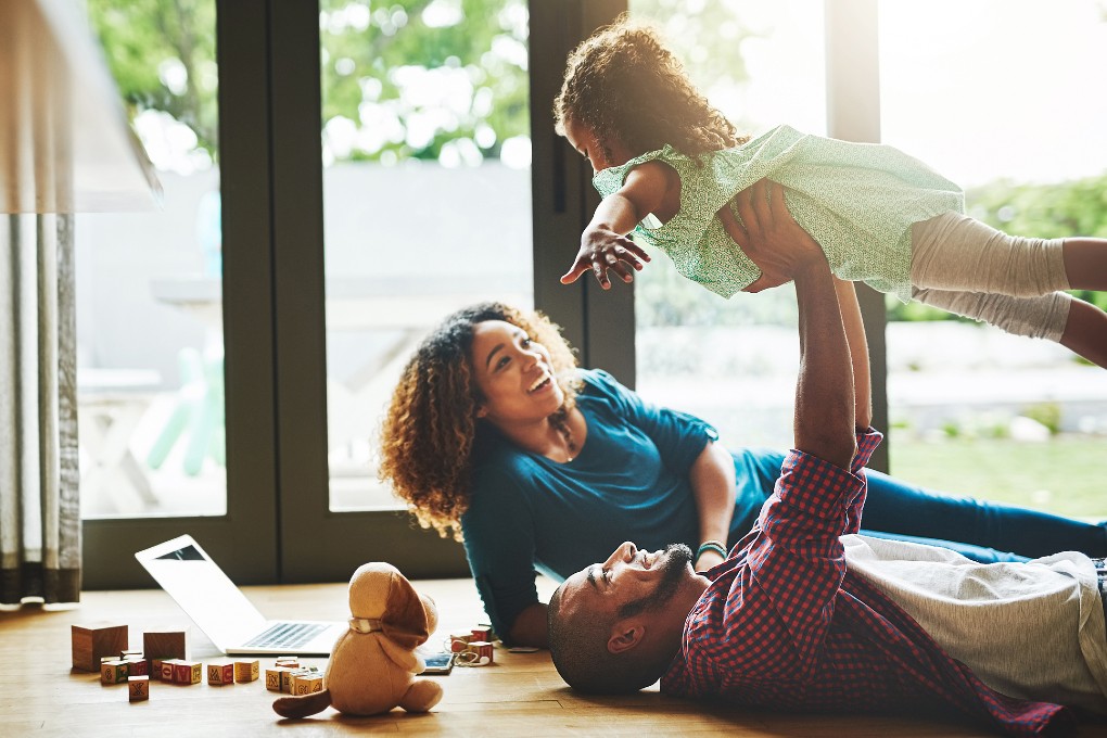 Conjoints de fait qui jouent avec leur enfant dans la salle familiale