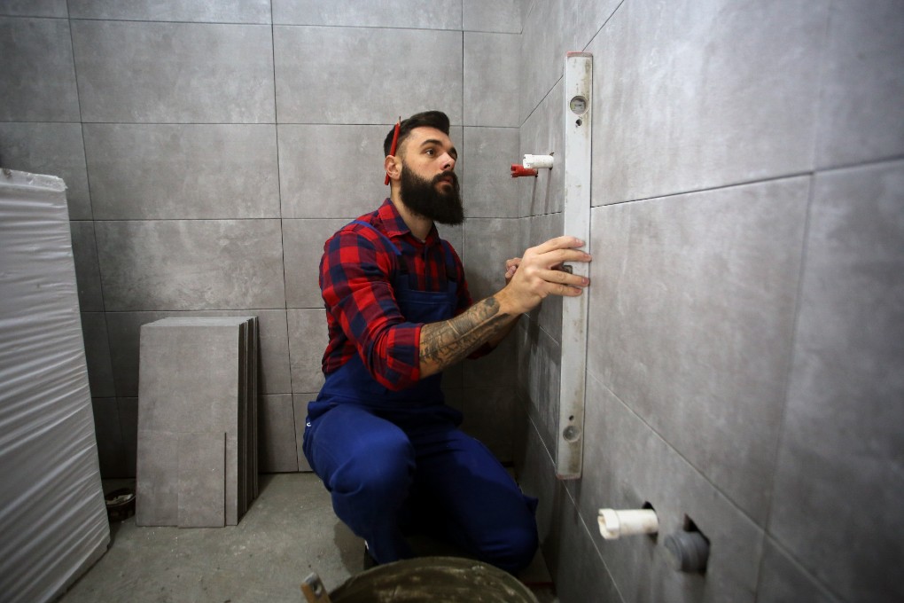 renovations-credits-impot-construction-mur.jpg Un ouvrier rénove un mur de céramique grâce à un crédit d’impôt.
