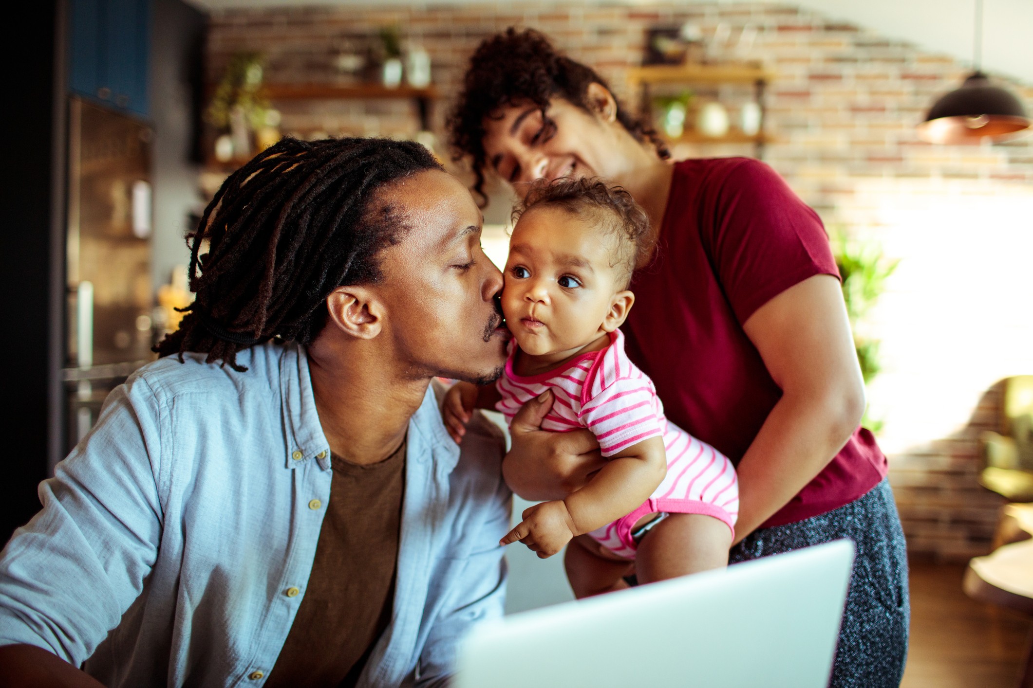 Un couple joue avec son enfant dans le salon.