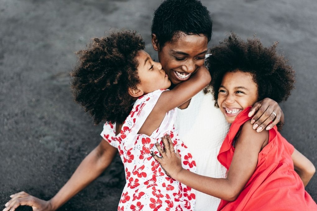 Un mère et ses deux jeunes filles qui rient et s’amusent