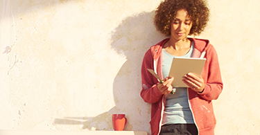 Jeune femme debout qui tient un cahier