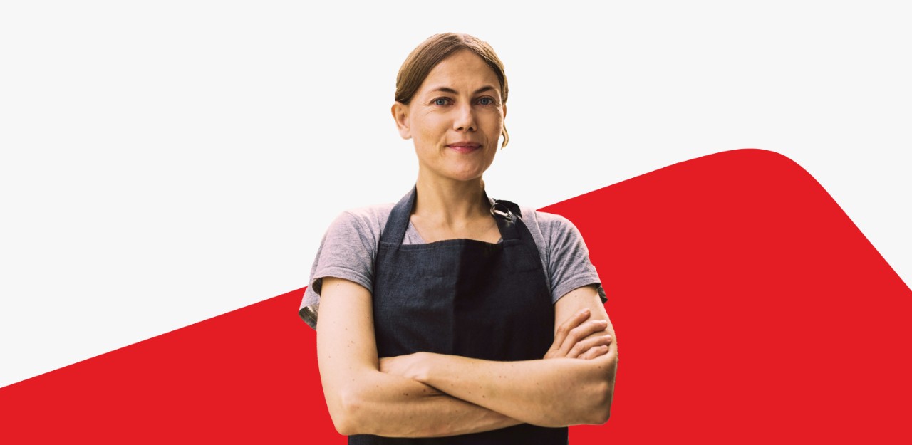 Photo d’une entrepreneuse les bras croisés sur fond de vague évoquant le logo Banque Nationale 