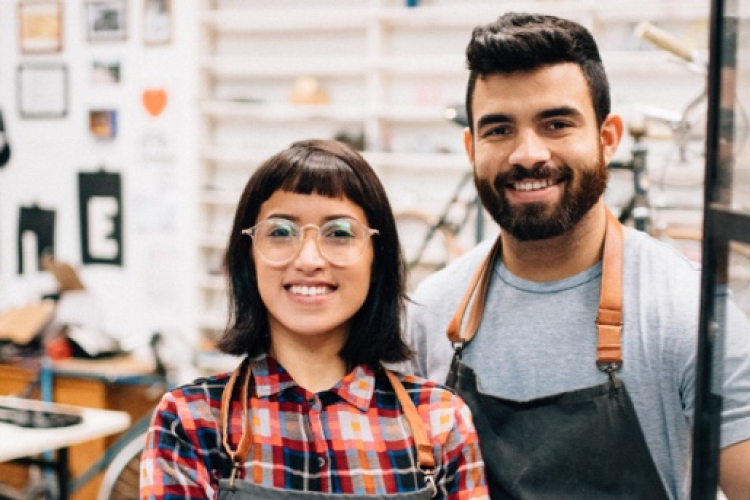 Photo de deux personnes dans un atelier de travail qui sourient 