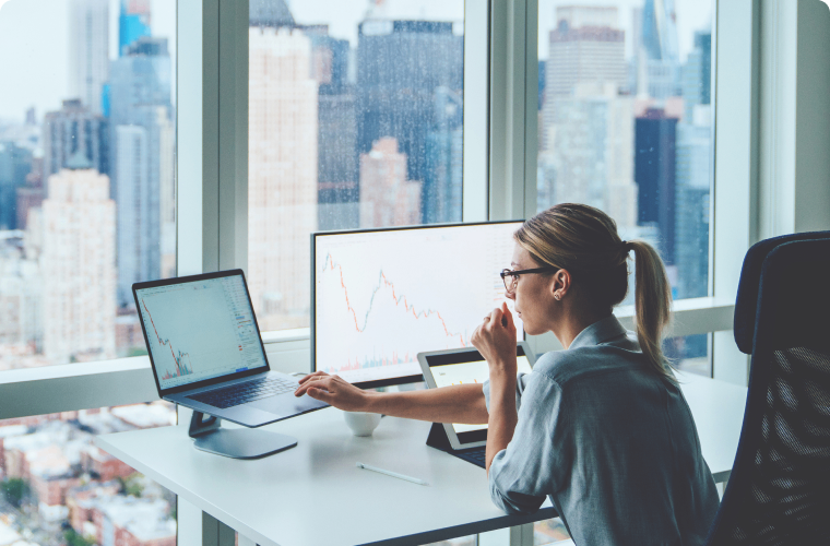 Photo d’une personne travaillant à l’ordinateur dans un bureau vitré d’une tour du centre-ville 