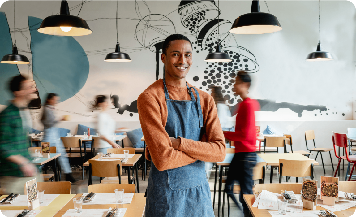 Photo d’un propriétaire de café se tenant debout entre des tables