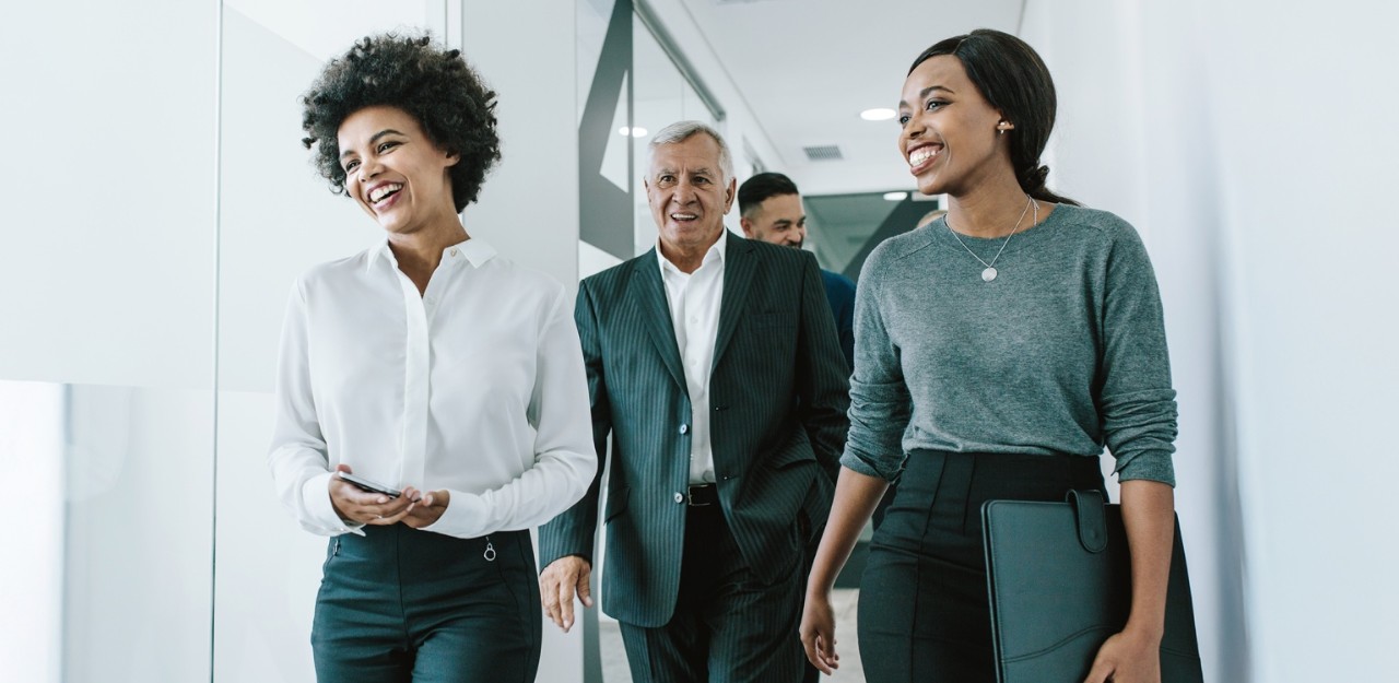 Photo of a group of people walking in an office 