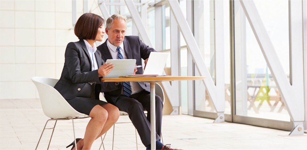 Photo de deux personnes en tenue d’affaires dans un bureau discutant de solutions de commerce international