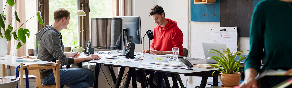 Deux individus travaillant ensemble à un bureau dans un environnement de bureau.