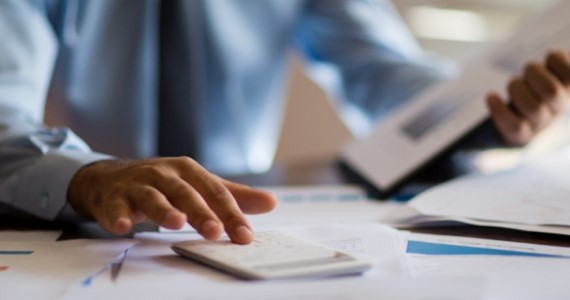 Image rapprochée d’une main d’homme qui utilise une calculatrice