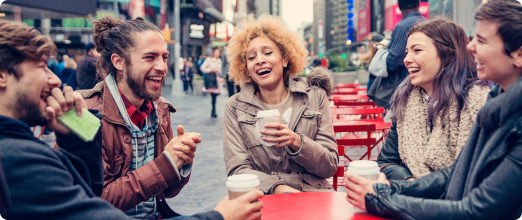 Photo d’un groupe d’amis en train de rire à la terrasse d’un établissement  