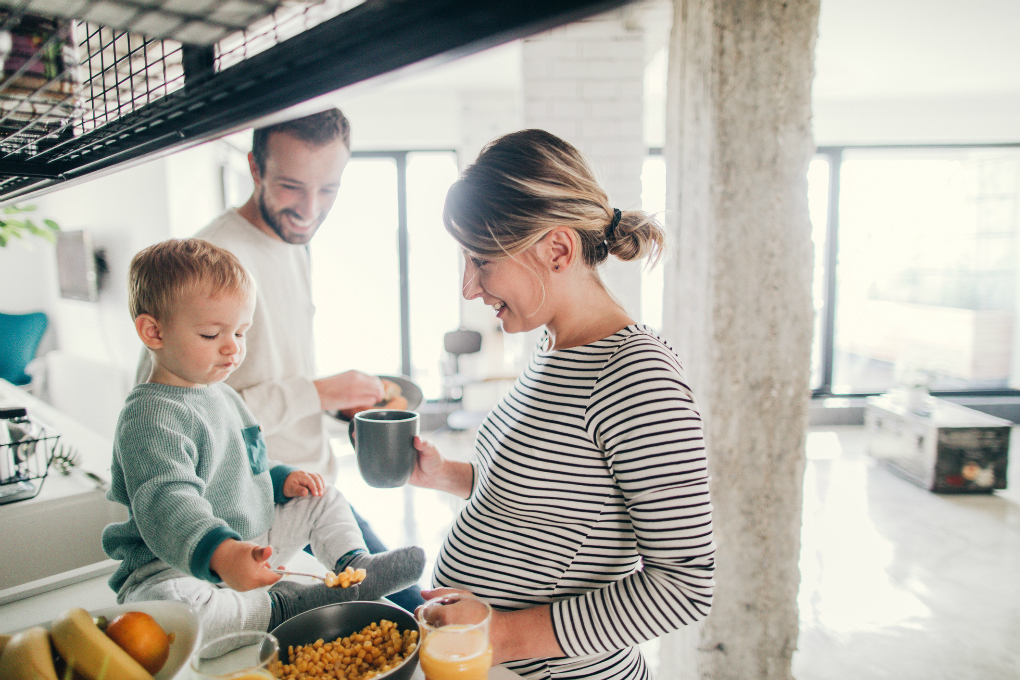 Photo d’un couple et leur fils debout dans leur cuisine